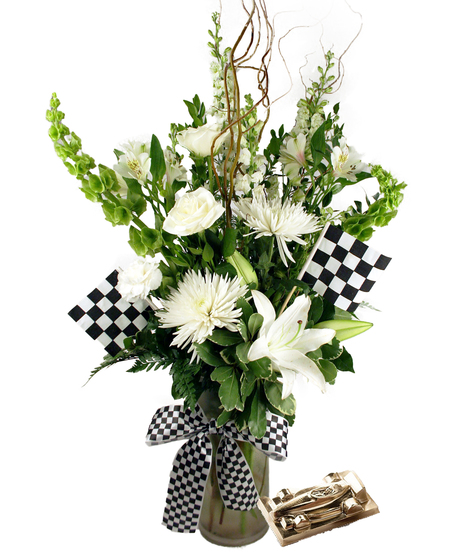 Image showcases the Race to Win Bouquet, featuring all-white flowers arranged in a frosted glass vase adorned with checkered flags and ribbon accents. 