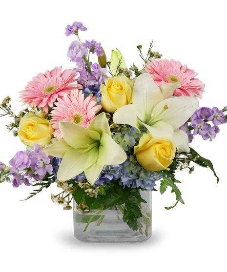 A mix of pastel-colored flowers in a glass cylinder vase 