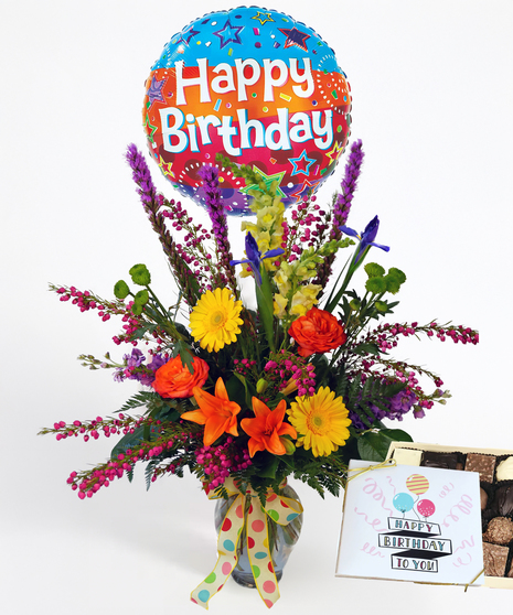 Bright bouquet of flowers in a blue vase presented with a balloon that reads 